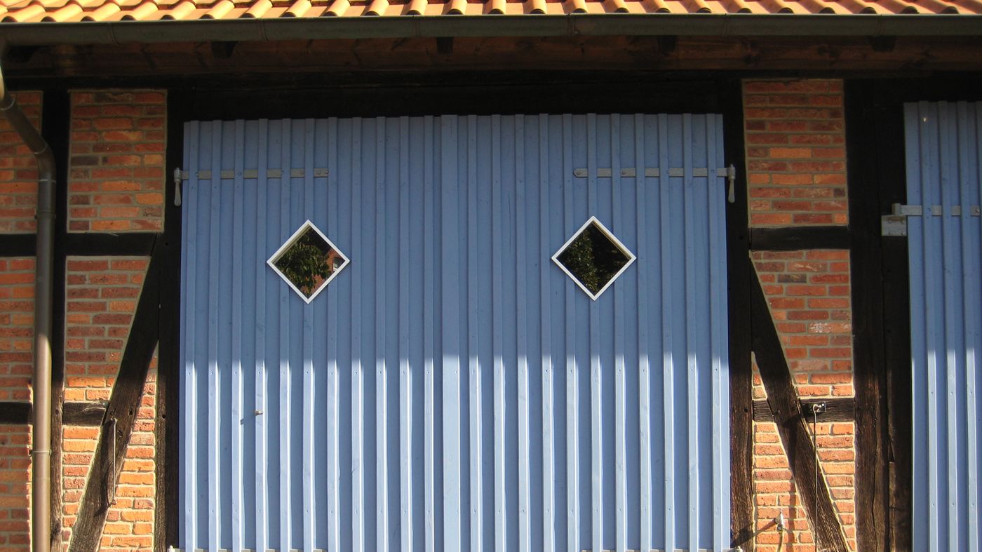 Blaues Tor mit kleinen Karofenstern