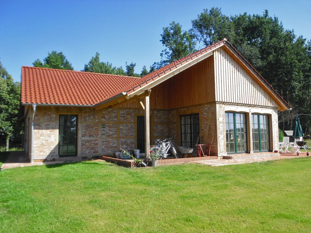 Ein Fachwerkbungalow mit Holzverschalung und großen Fensterflächen