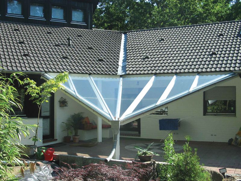 Terrasse die mit einem weißen Glasdach überdacht wurde